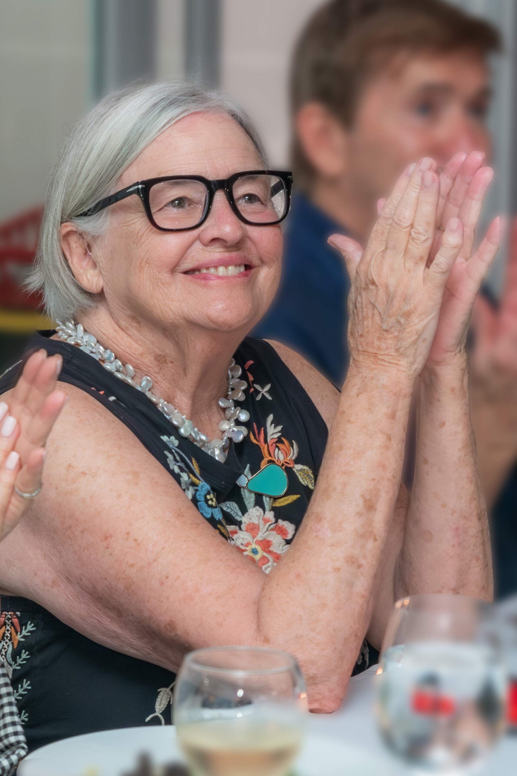 The Studios of Key West founder Peyton Evans smiling and applauding during an event.