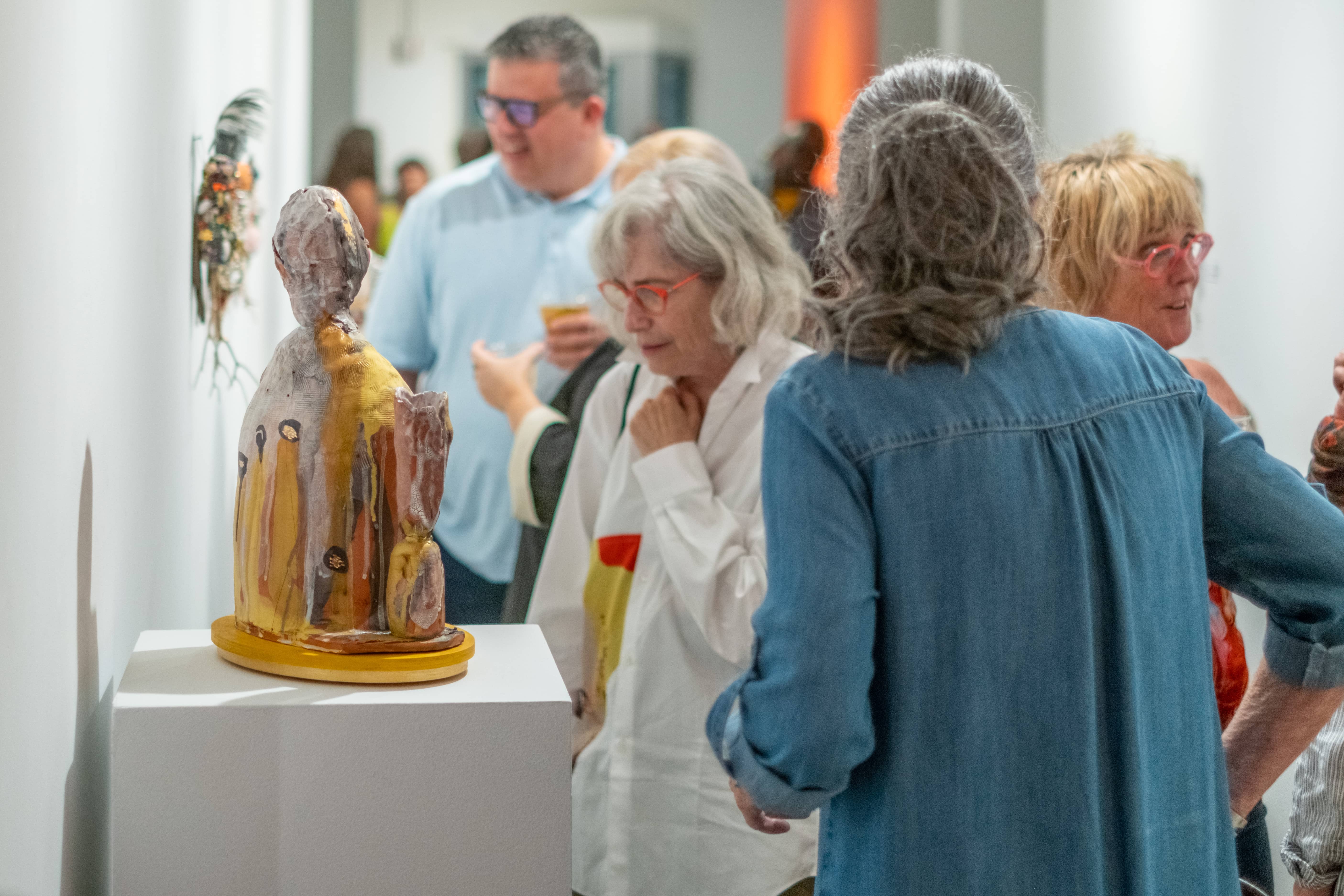 Visitors looking at a sculpture in the Studios of Key West gallery.