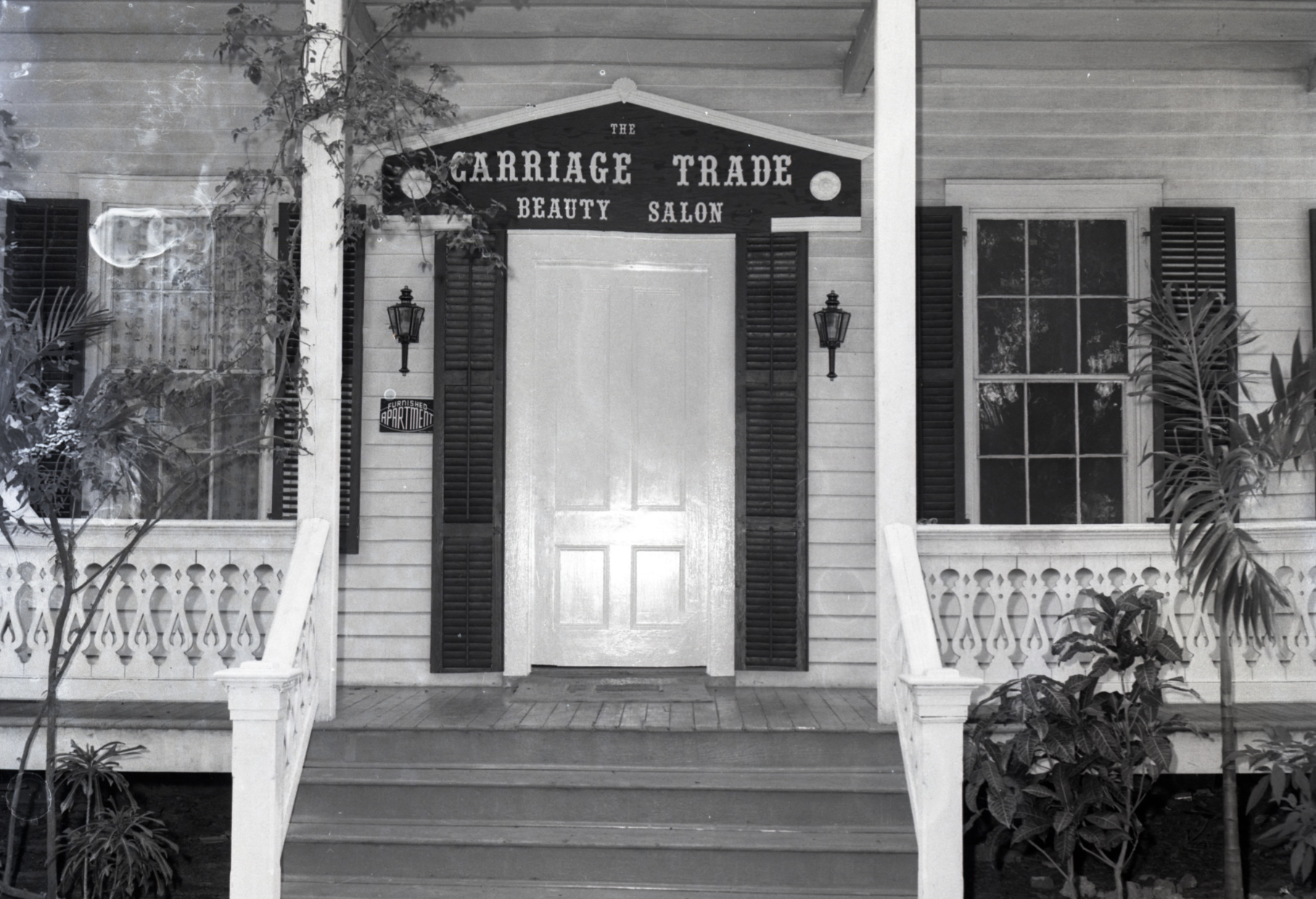 Black and white image of the historic guest house front porch.