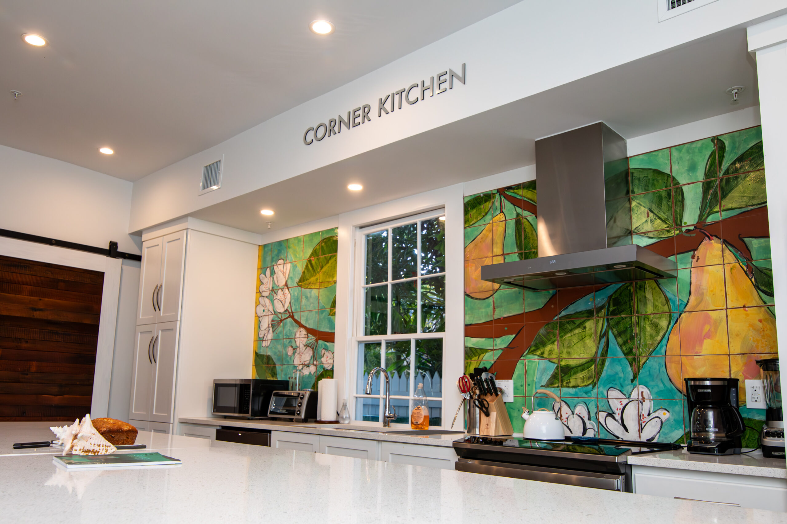 Kitchen wall with colorful tiling behind the stove.