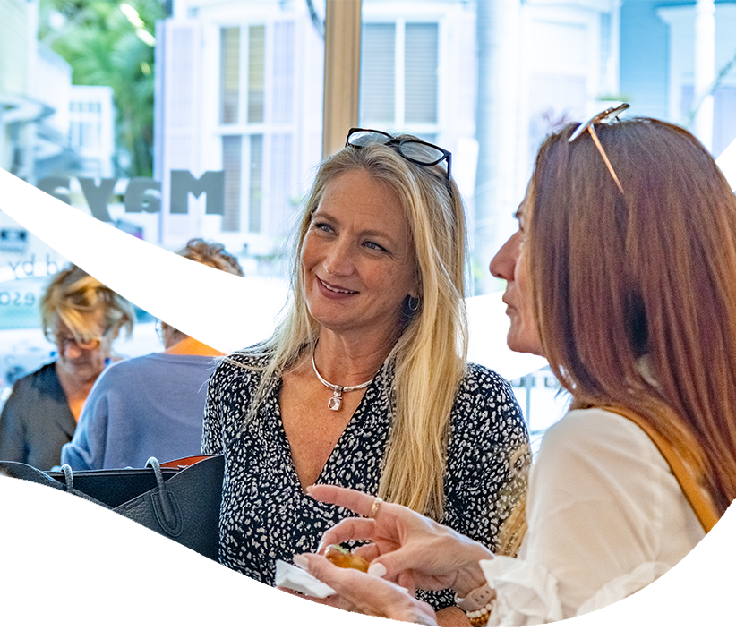 Two women chat during a gathering at The Studios of Key West.