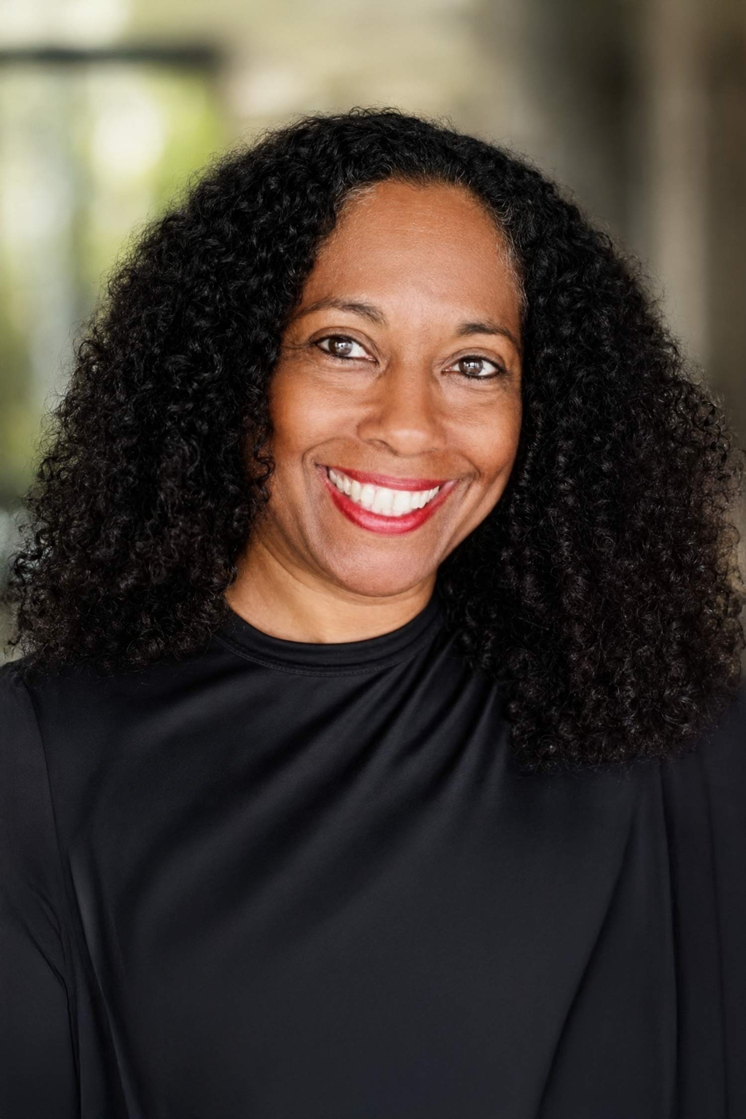 Cathleen Dean smiles in a black top against a softly blurred background.