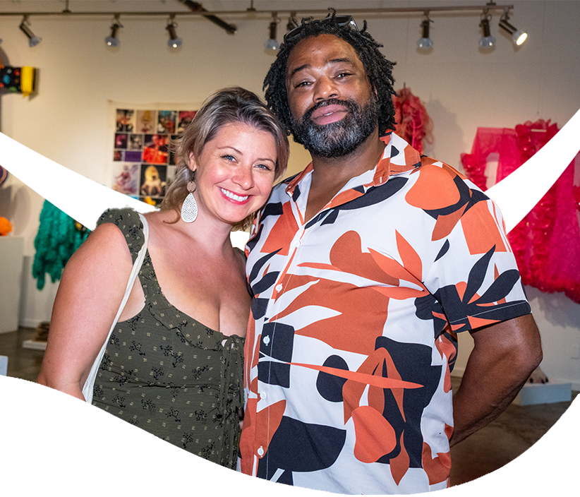 Two guests smile together while attending an exhibition opening at The Studios of Key West.