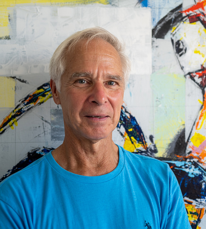 Matt Puppich standing in front of a large, colorful painting.