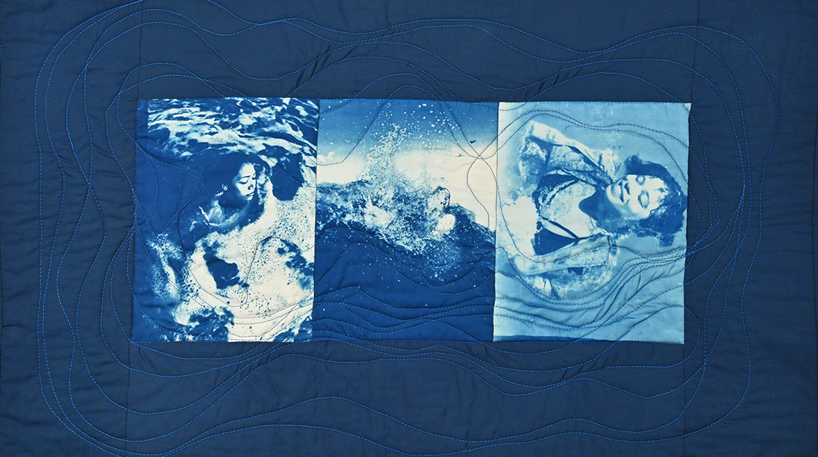 Blue quilted textile featuring three cyanotype images of figures immersed in water, surrounded by flowing stitched lines that evoke waves and currents.