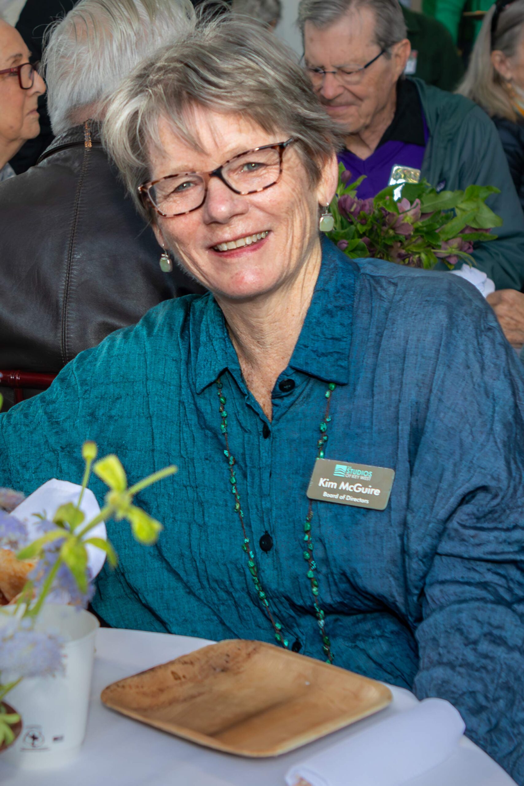 Kim McGuire smiling at a table during an event at The Studios of Key West.