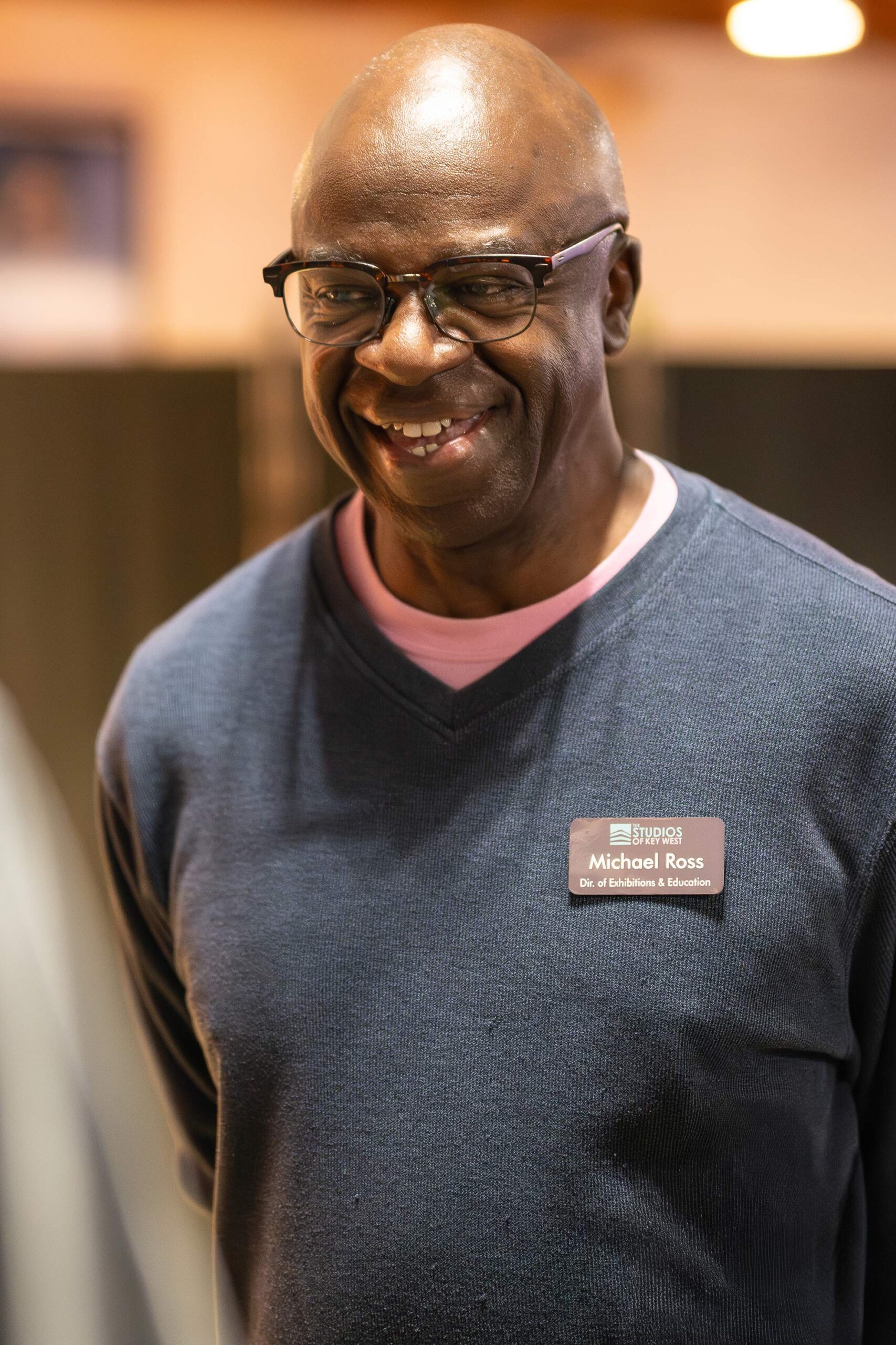 Michael Ross smiling at the camera and wearing glasses and a Studios of Key West name badge.