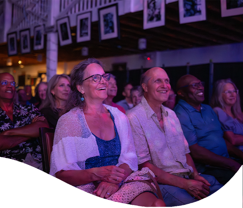 Audience members smile while enjoying a performance at The Studios of Key West.