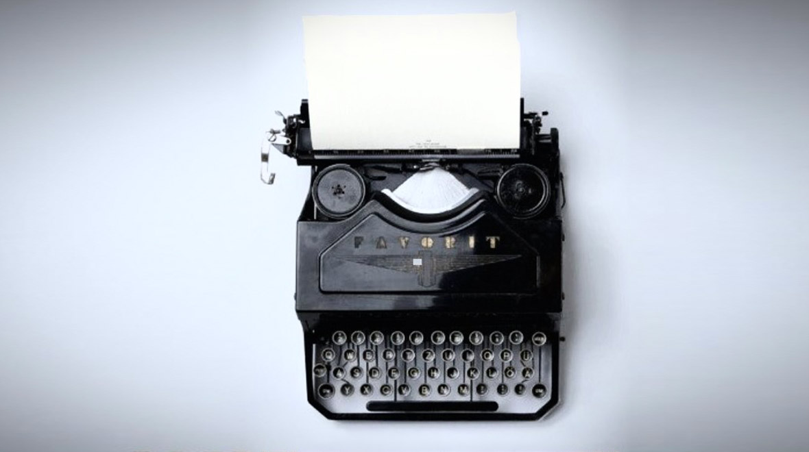 Vintage black typewriter with a blank sheet of paper, photographed from above against a white background.